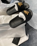 Woman’s black & gold slides