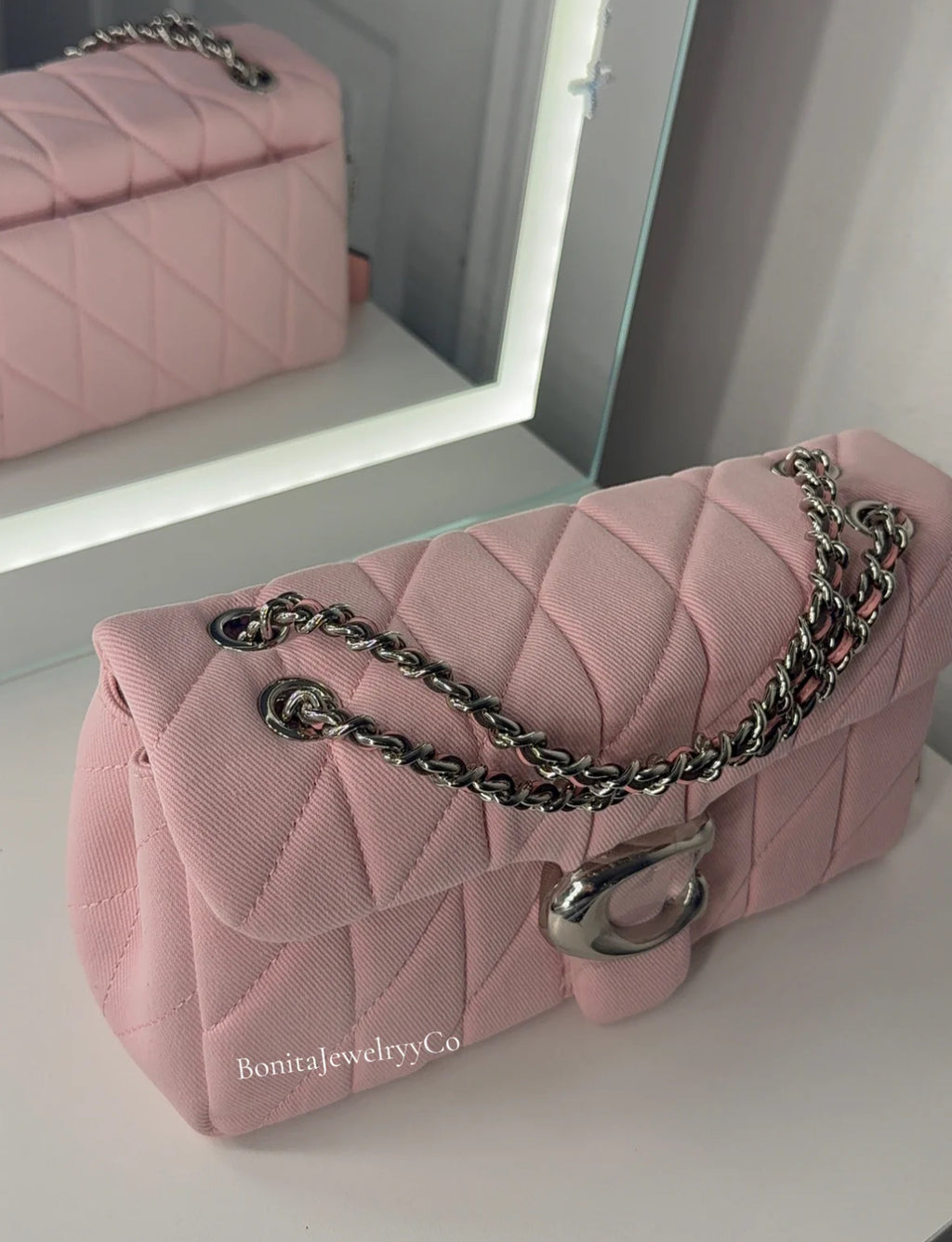 Pink cross body purse with silver wear