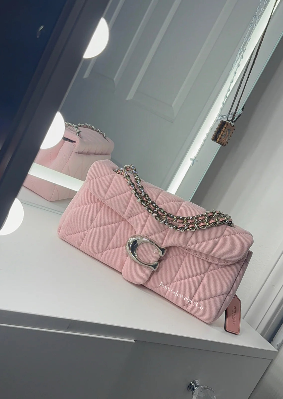 Pink cross body purse with silver wear