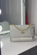 All white purse with gold strap