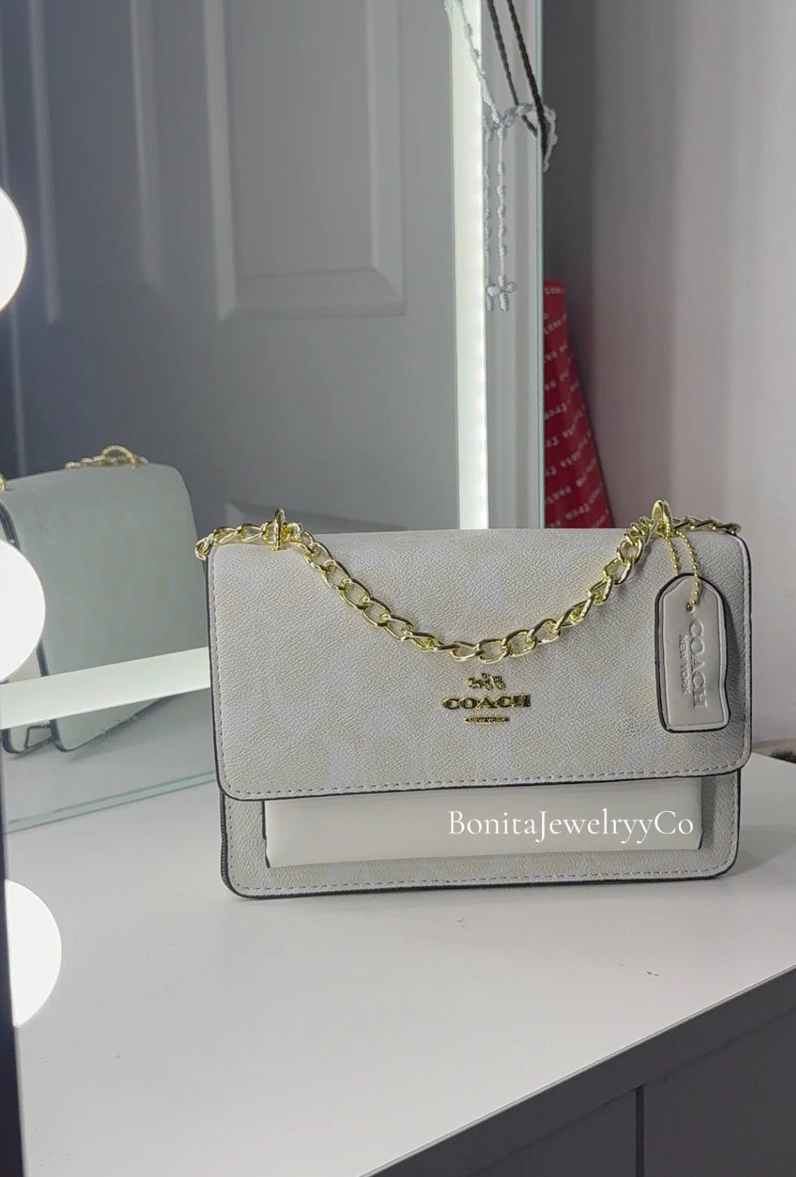 All white purse with gold strap